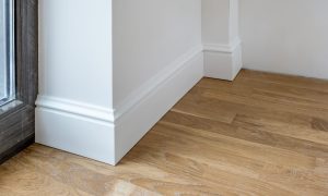 Detail of corner flooring with intricate crown molding and plinth.
